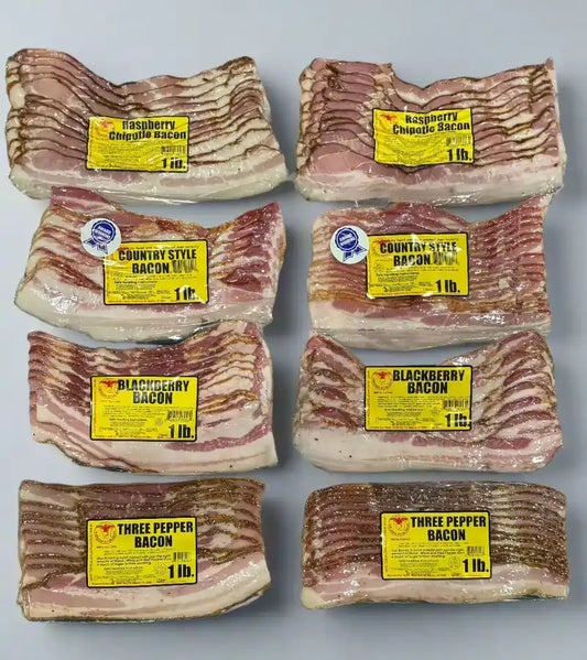 Four 1 lb vacuum‑sealed packs in a gourmet bacon sampler box – country‑style classic, blackberry glazed, raspberry chipotle, and three‑pepper bacon variety pack
