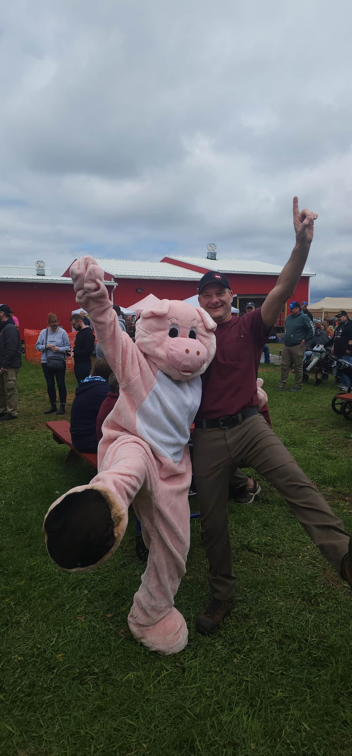 David Mauer, Vice President of Wisconsin River Meats, posing with a pig mascot at an outdoor community event.