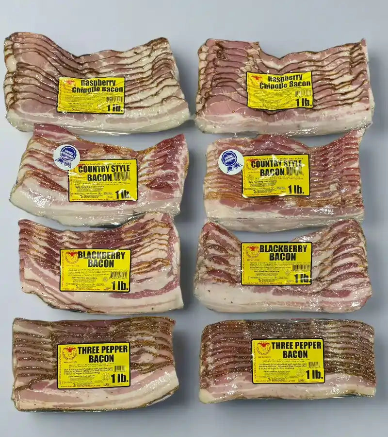 Four 1 lb vacuum‑sealed packs in a gourmet bacon sampler box – country‑style classic, blackberry glazed, raspberry chipotle, and three‑pepper bacon variety pack