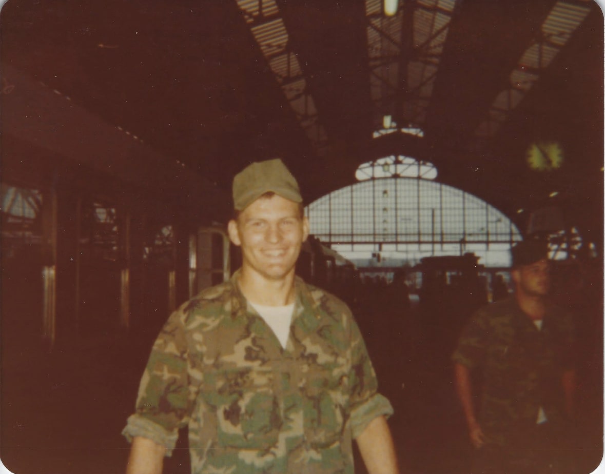 Young John Hamm, President of Wisconsin River Meats, wearing a military uniform inside a train station.
