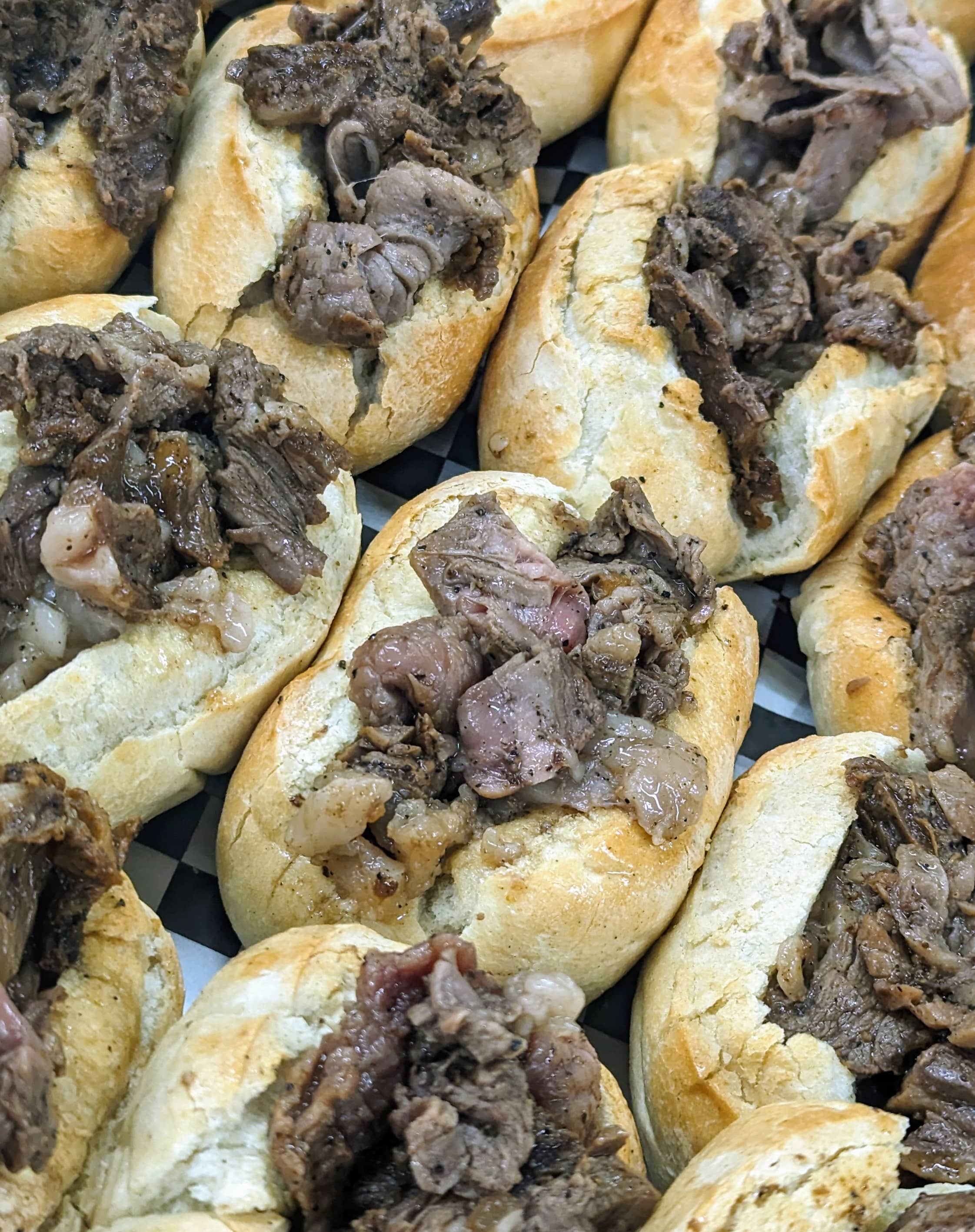 Fresh rolls filled with tender, seasoned prime rib prepared for sandwiches.