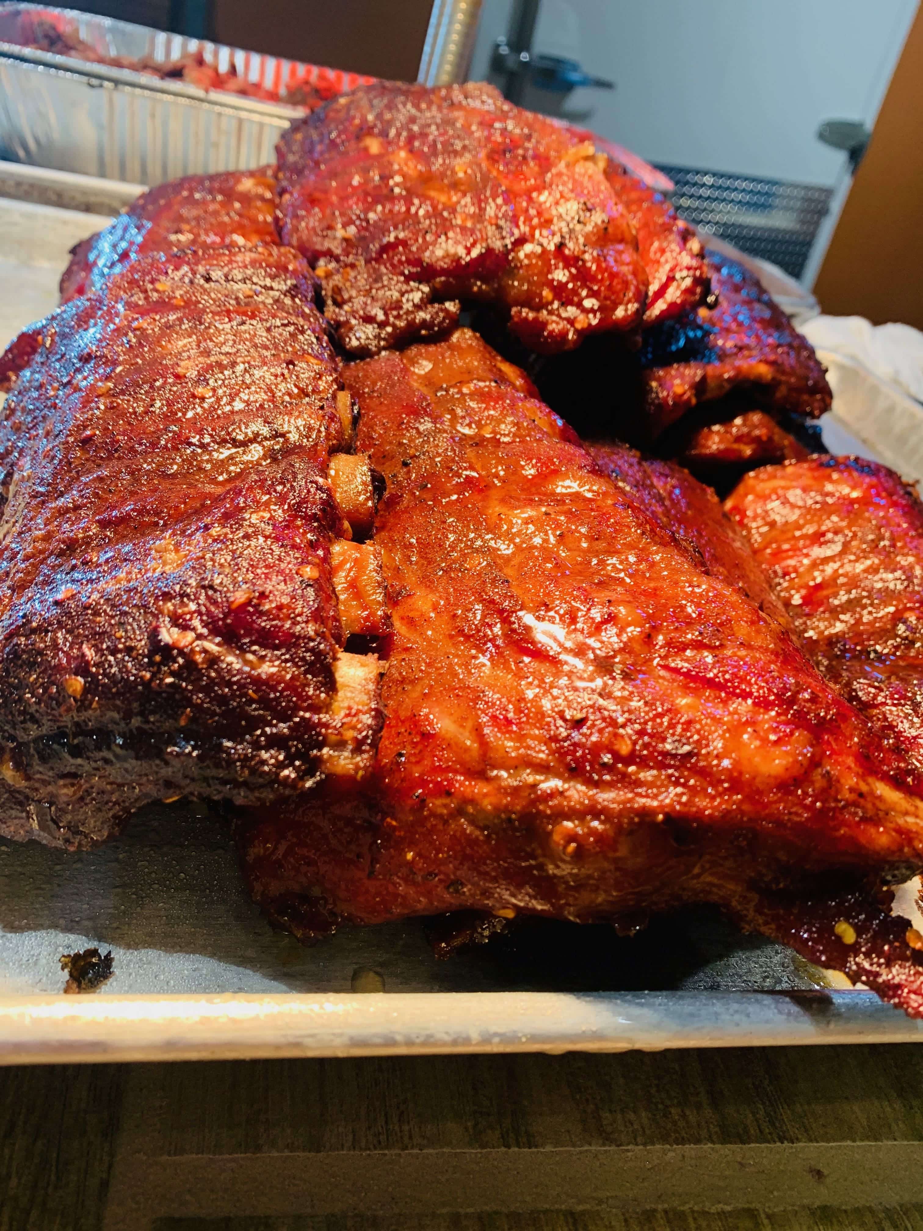 Close-up of glazed smoked barbecue ribs stacked on a tray at Wisconsin River Meats.