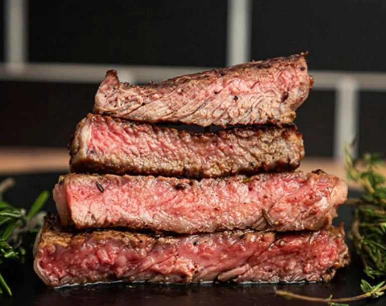Sliced grilled steaks stacked on a plate